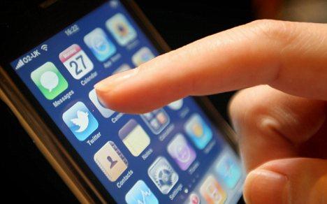 Black iPhone with a finger touching an icon on the screen.