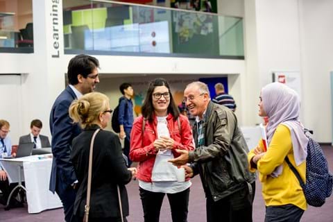 Three women and two men sharing a joke at OR59