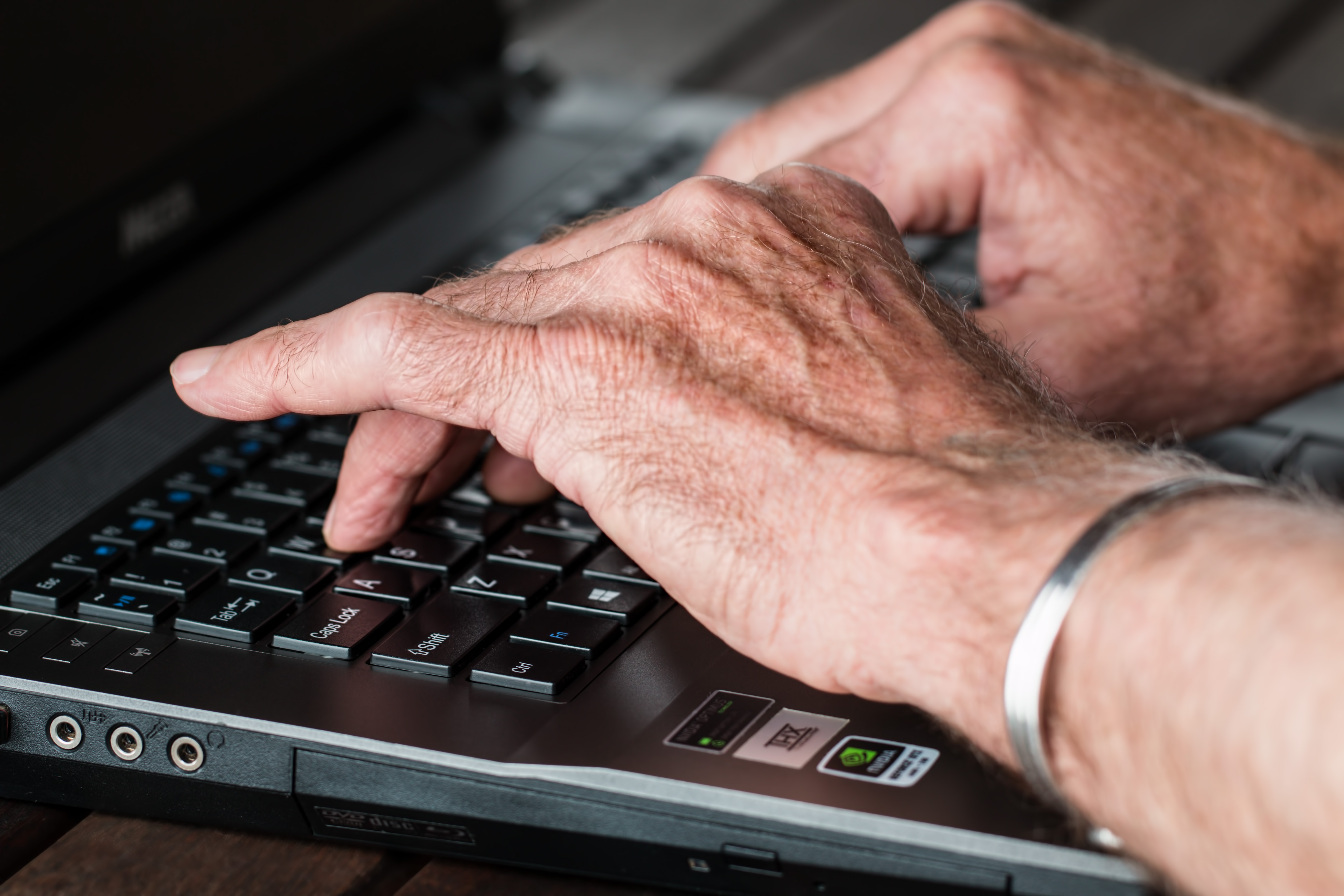 Hands typing on a laptop keyboard.