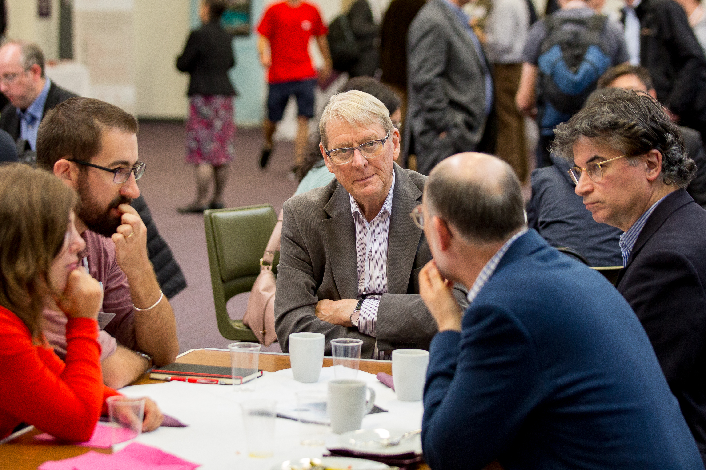 Group of different ages in discussion over coffee at OR59