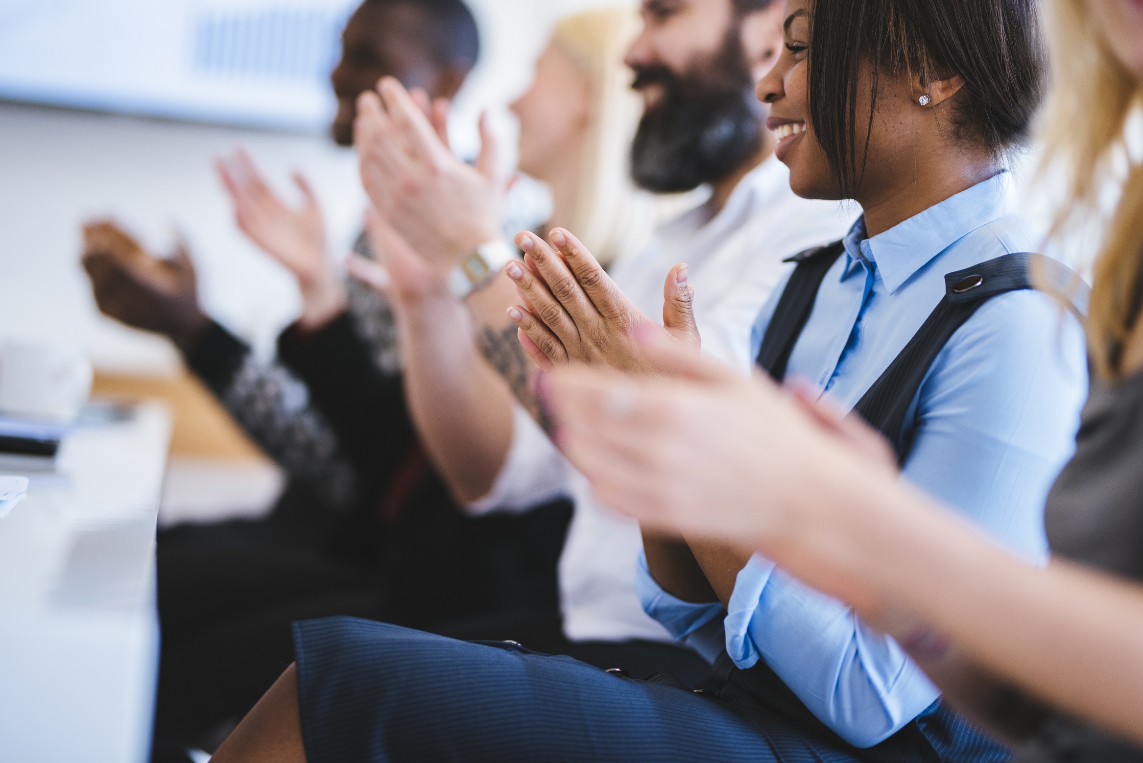 Multi-ethnic audience applauds.